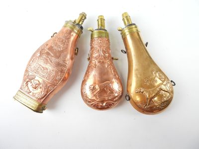 trois bouteilles de vin anciennes sont alignées sur une surface blanche