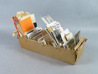 une boîte en carton remplie de livres posée sur une surface blanche