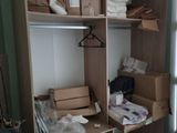 un placard sur lequel sont posés de nombreux cartons et vêtements