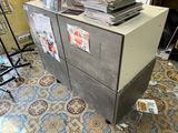 a stack of papers sitting on top of a filing cabinet