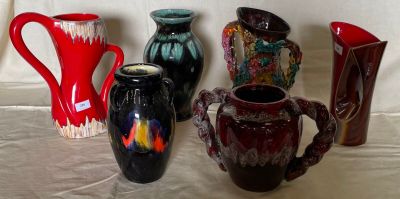 many different vases sitting on a table with a white background