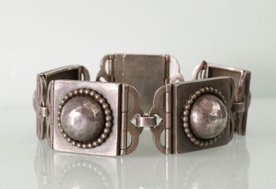 bracelet en métal argenté et perles de verre sur un fond blanc