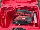 une boîte à outils rouge contenant des outils, posée par terre