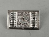 a close up of a silver buckle with a picture on it