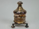 un vase en argent et en or posé sur un socle, sur fond blanc
