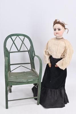 an image of a doll sitting next to a chair on a white background