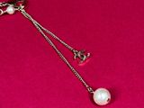 necklace with a pearl and a chain on a pink surface