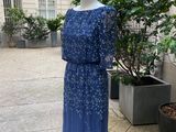 La robe est posée sur un mannequin devant une plante en pot.