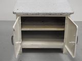 a small white cabinet with a door open on a gray floor