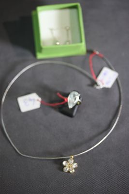 a necklace with a cross on it and a box with a watch
