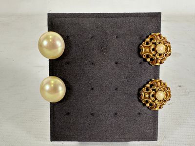 two pairs of pearl and gold earrings on a black surface