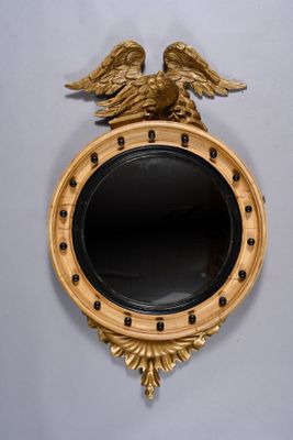 a gold mirror with an eagle on top of it