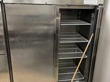 a stainless steel refrigerator in a kitchen with a broom in front of it