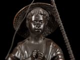 bronze statue of a boy with a stick and a hat