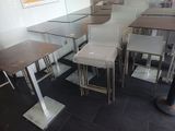 des tables et des tabourets dans un restaurant au sol carrelé de noir