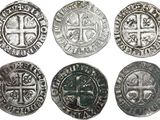 six pièces d'argent ornées de croix sur fond blanc