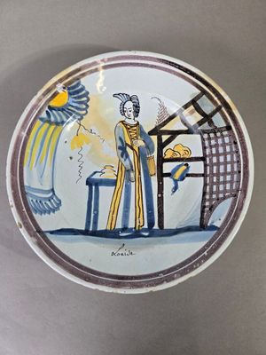 une assiette avec l'image d'une femme et d'un oiseau