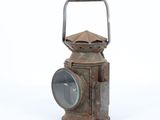an old rusty lantern sitting on a white surface