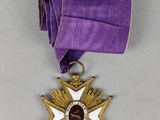 a close up of a medal with a purple ribbon around it