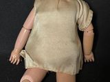 a doll that is laying down on a black surface