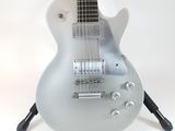 a guitar that is sitting on a stand on a white background