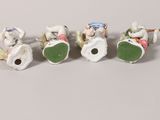 four porcelain figurines of people riding on a horse and carriage
