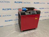 a red machine sitting on top of a floor next to a wall