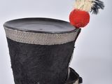 a black top hat with a red and white pom pom sticking out of it
