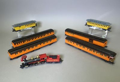 trois trains miniatures assis l'un à côté de l'autre sur une table