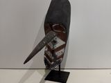 a metal sculpture of a bird with a knife on it ' s head