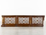 une console ancienne en bois avec des éléments en fer forgé sur les côtés