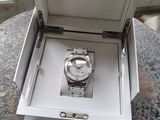une boîte ouverte contenant une montre, posée sur une table