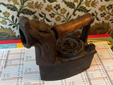 an old iron that is on a table with a calendar on it