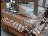 un chariot sur lequel est posé un matelas, dans un entrepôt