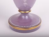 a purple vase with a gold rim sitting on a white surface