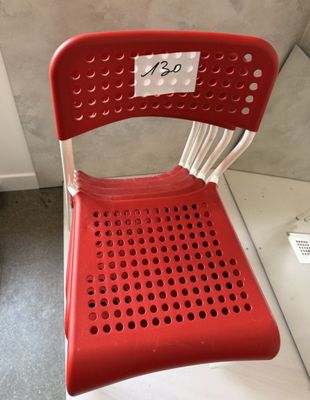 une chaise en plastique rouge sur laquelle est accrochée une étiquette de prix