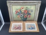 deux photos encadrées de fleurs dans un vase sur une table
