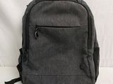 grey backpack sitting on a white surface with a white background