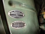 a close up of a green motorcycle with a number plate on it