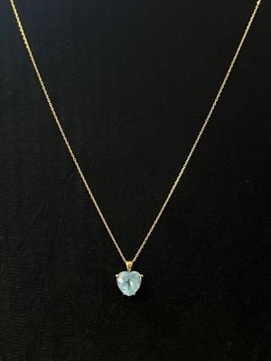 un collier plaqué or orné d'un pendentif en topaze bleue