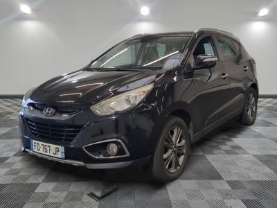 la voiture noire est garée sur un sol en damier dans le garage
