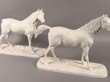 two figurines of horses standing on a table