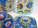three plates with different designs on them sitting on a white surface
