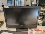 a computer monitor sitting on a desk in a room