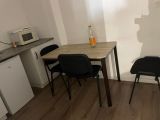 une petite cuisine avec une table et des chaises