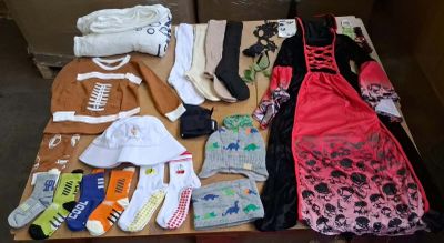 many pairs of shoes and clothes laid out on a table