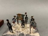 several figurines of men dressed in military uniforms on a table