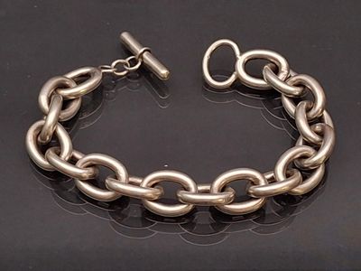 bracelet à chaîne plaquée argent avec fermoir, sur fond noir