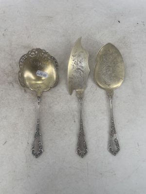 three silver spoons and a spoon on a white surface