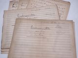 quatre feuilles de papier à musique usagé posées sur une table
